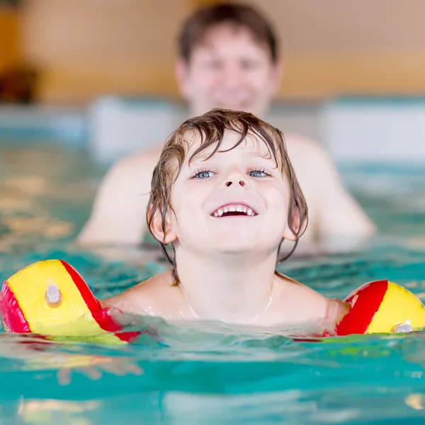 Menino e seu pai nadando em uma piscina interior — Fotografia de Stock