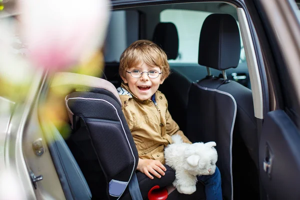 Muotokuva esikoulupoika poika istuu autossa — kuvapankkivalokuva
