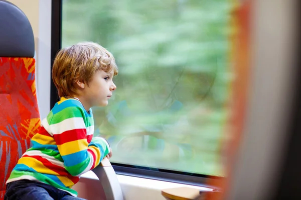 Little boy sitting in train and going on vacations — Zdjęcie stockowe