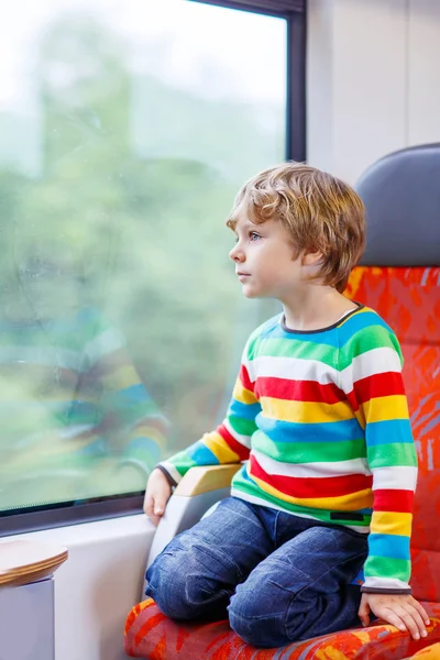 Menino sentado no trem e indo de férias — Fotografia de Stock