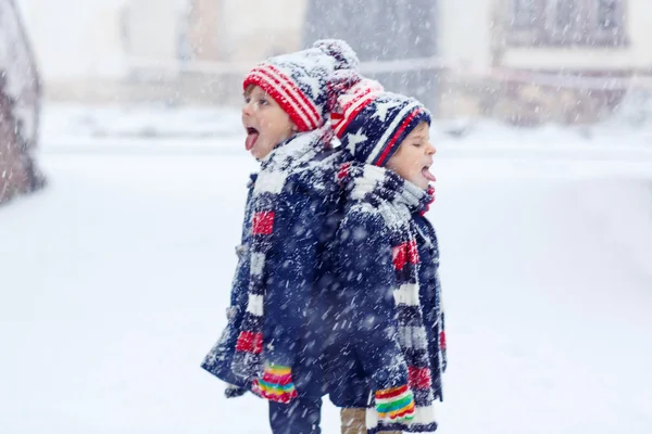 Dos niños felices divirtiéndose con nieve en invierno —  Fotos de Stock