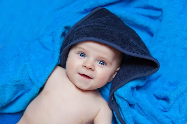 Menino menino pequeno contra a toalha de banho azul — Fotografia de Stock