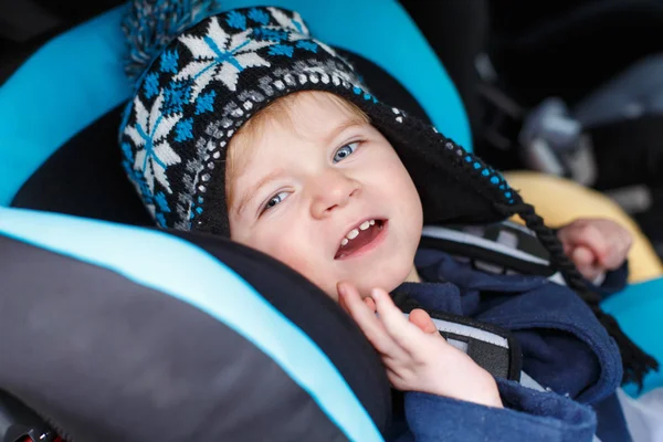 Adorable toddler boy sitting in safety car seat — ストック写真