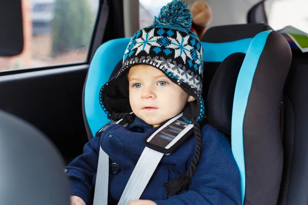 Adorable toddler boy sitting in safety car seat — Stok fotoğraf