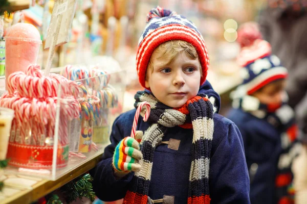 Petit garçon avec stand de canne à sucre sur le marché de Noël — Photo