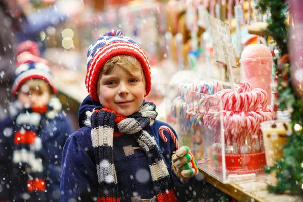 Petit garçon avec stand de canne à sucre sur le marché de Noël — Photo