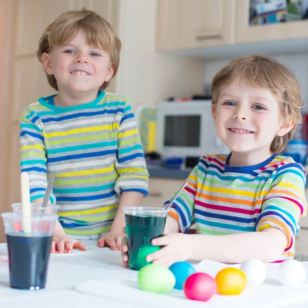 Zwei kleine blonde Jungen färben Eier für die Osterfeiertage — Stockfoto