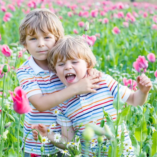 Two happy little blond children in blooming poppy field — Stock Photo, Image