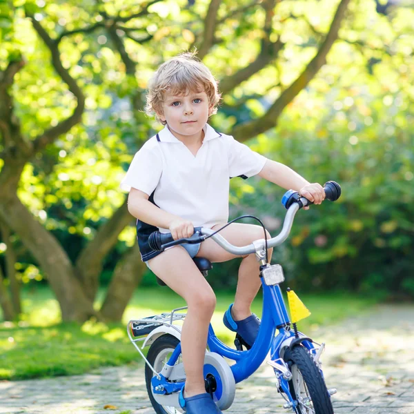 Маленький мальчик из детского сада летом катается на велосипеде — стоковое фото