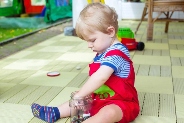 Kleine jongen een jaar oud spelen met kleurrijke knikkers — Stockfoto