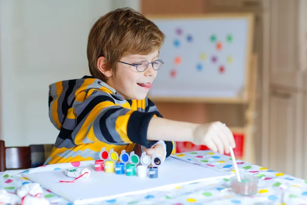 Menino desenho com aquarelas coloridas dentro de casa — Fotografia de Stock