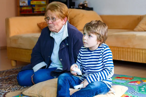 Little kid boy and grandmother playing video game console — Stock Photo, Image