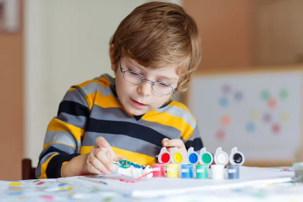 Liten unge pojke ritning med färgglada akvareller inomhus — Stockfoto