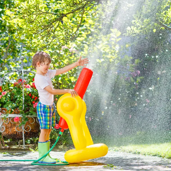 Kleine jongen jongen spelen met een tuinslang — Stockfoto