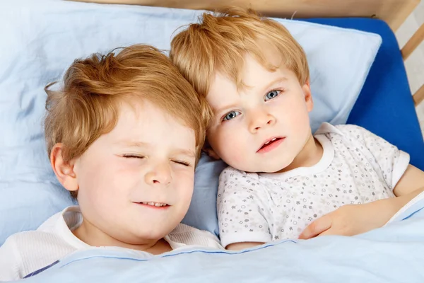 Kleine broer of zus jongens plezier in bed thuis — Stockfoto