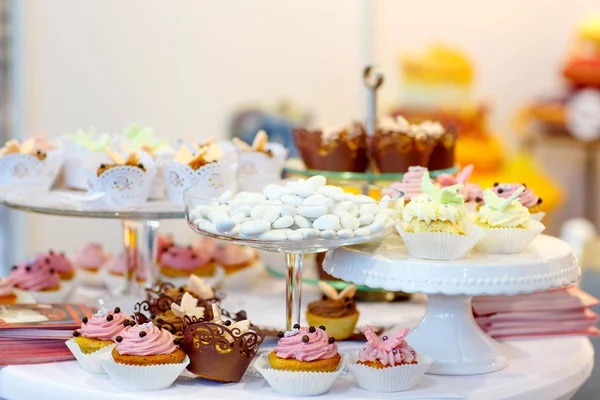 Elegante mesa doce com cupcakes, bolos e doces no jantar — Fotografia de Stock