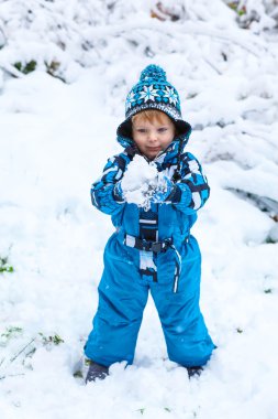 Mutlu çocuk kışın kar ile eğleniyor