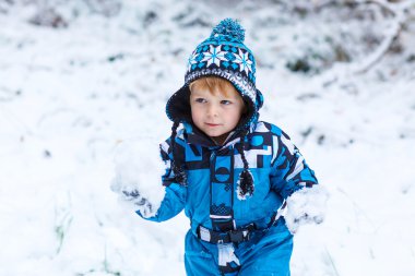 Mutlu çocuk kışın kar ile eğleniyor