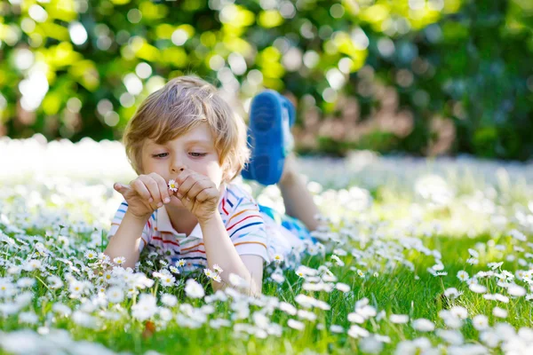 Niño lindo acostado sobre hierba verde en verano — Foto de Stock