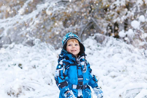 Fröhliches Kind, das im Winter Spaß mit Schnee hat — Stockfoto