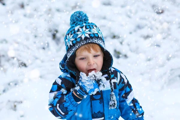 Happy child having fun with snow in winter — Stock Photo, Image