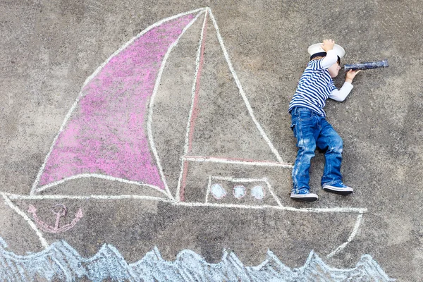 Kleine jongen met plezier met schip afbeelding tekenen met krijt — Stockfoto