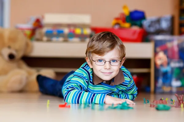 Ragazzo ragazzo che gioca con i soldatini giocattolo al chiuso in vivaio — Foto Stock