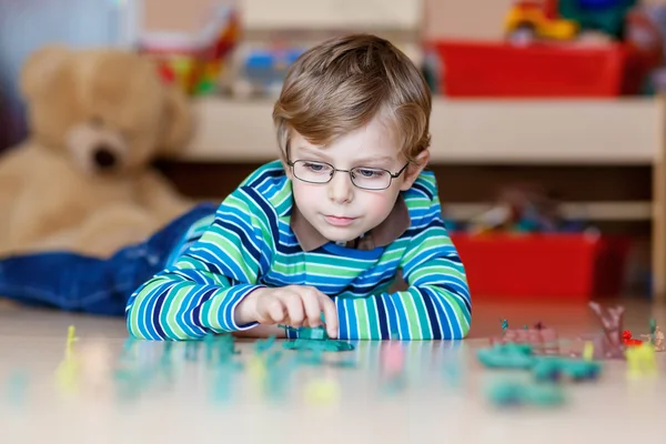 Kid boy playing with toy soldiers indoors at nursery — Stock Photo, Image