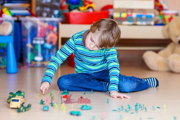 Garoto brincando com soldados de brinquedo dentro de casa no berçário — Fotografia de Stock