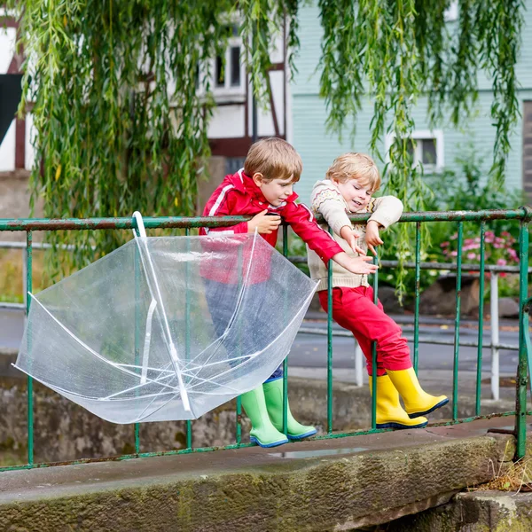 Two little kid boys with big umbrella outdoors — Stock Photo, Image