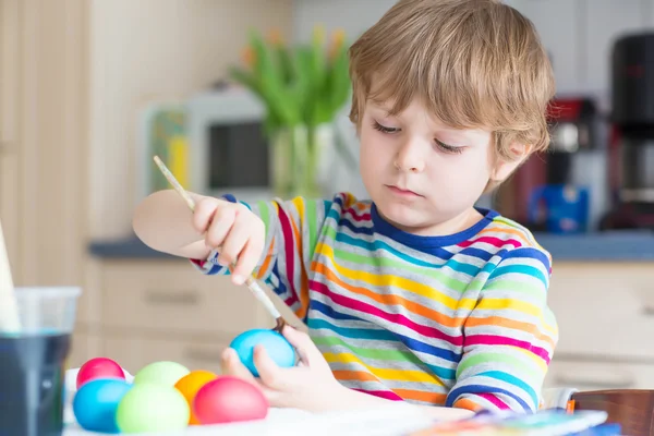 Kid jongetje kleuren eieren voor paasvakantie — Stockfoto