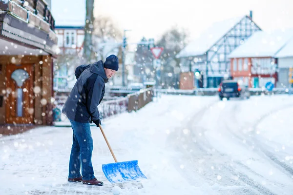 冬天，拿着铲子的人清扫人行道 — 图库照片