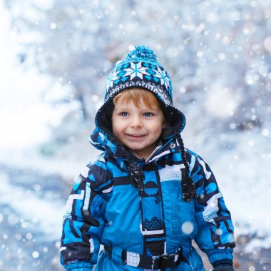 Mutlu çocuk kışın kar ile eğleniyor