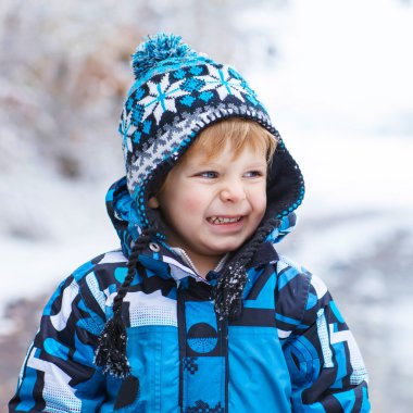 Mutlu çocuk kışın kar ile eğleniyor