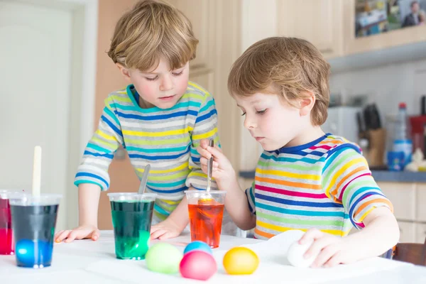 Twee kleine blonde jongen jongens kleuren eieren voor paasvakantie — Stockfoto