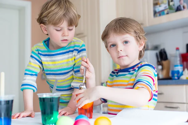 Twee kleine blonde jongen jongens kleuren eieren voor paasvakantie — Stockfoto