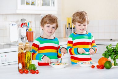 İki küçük çocuklar yerli mutfakta spagetti yiyen çocuk.
