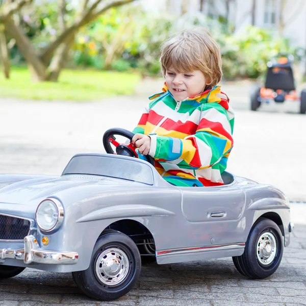 Twee gelukkige broer of zus jongens spelen met grote oude speelgoedauto — Stockfoto