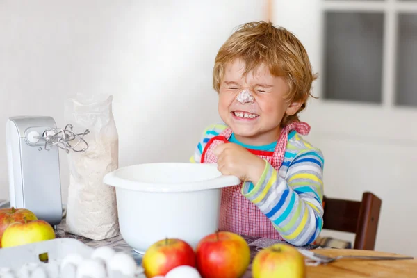 Legrační blonďaté dítě chlapec pečení jablečný dort doma — Stock fotografie