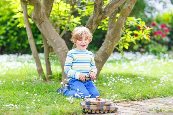 Bonito criança brincando com brinquedo tanque — Fotografia de Stock