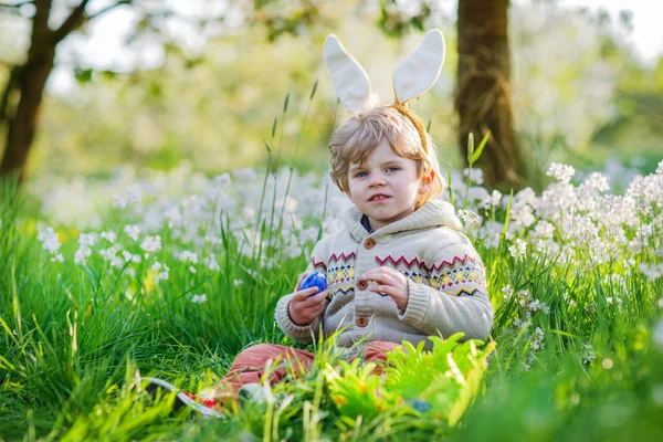 Bonito menino feliz vestindo orelhas de coelho de Páscoa na primavera verde — Fotografia de Stock