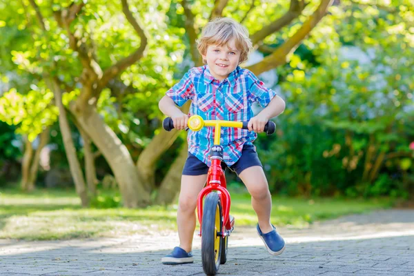 庭で三輪車や自転車を運転していた男の子を子供します。 — ストック写真