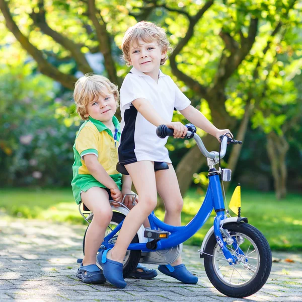 Two little kid boys riding with bicycle together — Stock Photo, Image