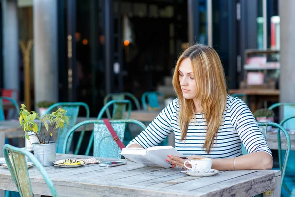 Mujer bebiendo café y leyendo libro en la cafetería —  Fotos de Stock