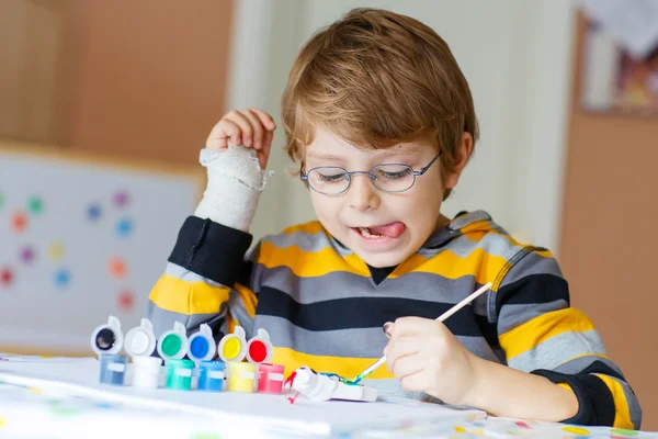 Liten unge pojke ritning med färgglada akvareller inomhus — Stockfoto