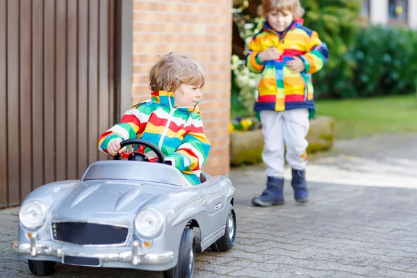 Två glada syskon pojkar leker med stor gammal leksaksbil — Stockfoto