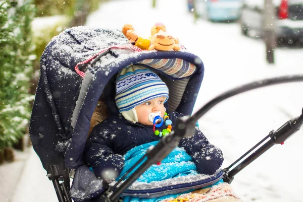 Pojke i vagnen under vinter snö faller — Stockfoto