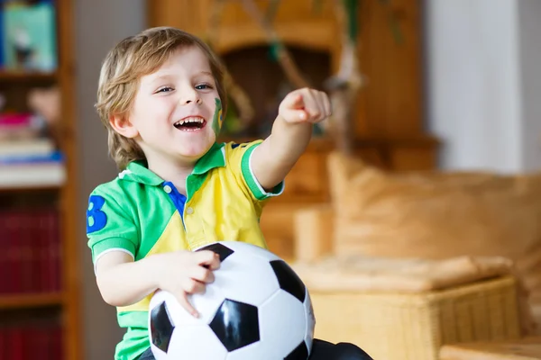 Little blond preschool boy of 4 years with football looking socc — Stock Photo, Image