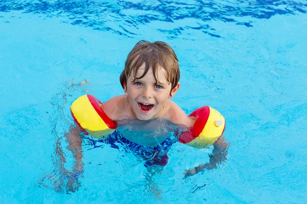 Little boy having fun in an swimming pool — Stockfoto