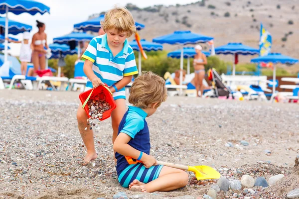 Dois garotos brincando na praia com pedras — Fotografia de Stock